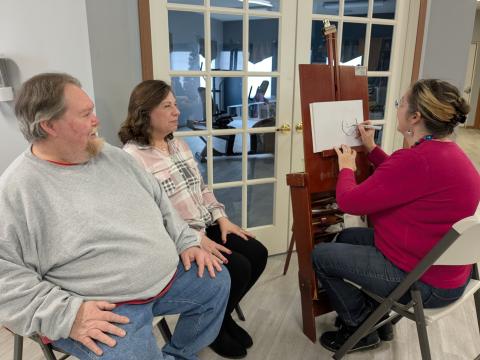 Artist Wendy Carrick doing caricatures for Kenton Station residents.