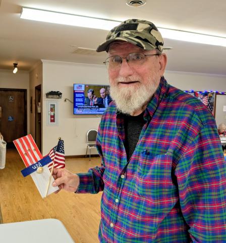 Gentleman displaying the wooden Uncle Sam craft he made.